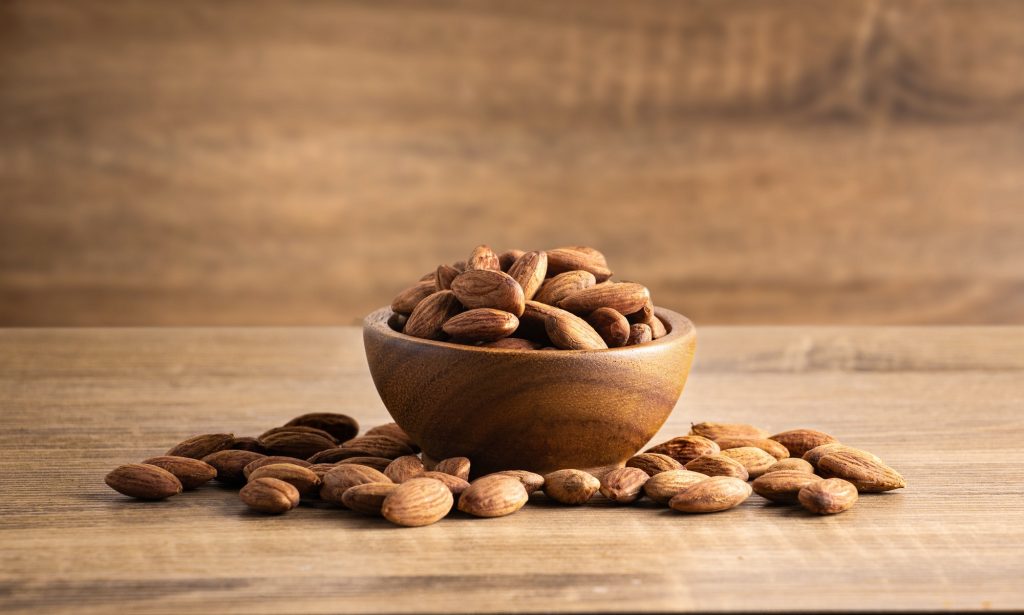 Peeled almonds wood bowl on wooden